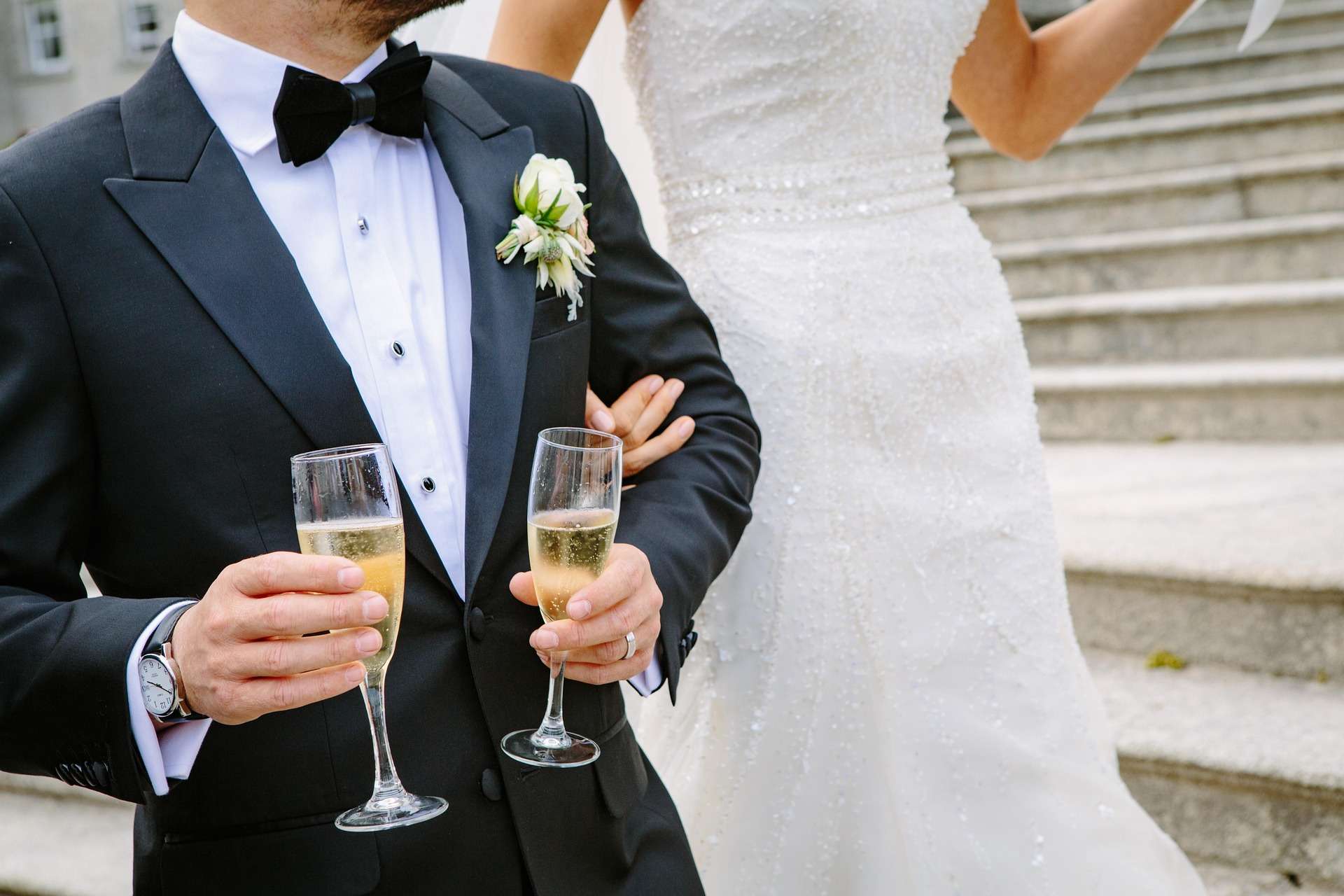 Un couple de mariés qui porte des verres de champagne